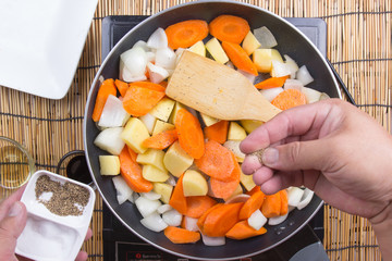 Chef putting the salt and pepper to the pan for cooking