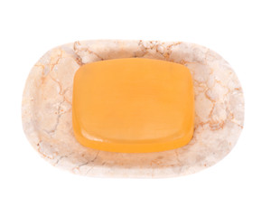 Goat milk soap on beige marble dish separated on white background