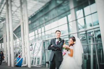 Romantic gentle gorgeous bride and groom on the background of modern futuristic architecture