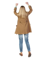 Back view of woman. Raised his fist up in victory sign. blonde in a brown cloak, a fan of the team waving his arms.