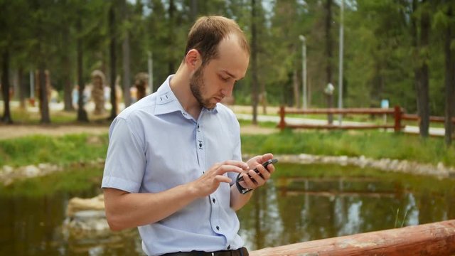 Man using mobile smart phone in park, iphon style.