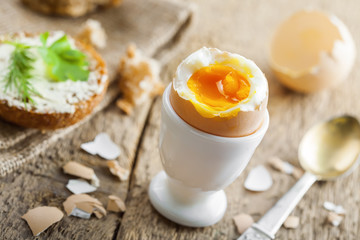 Healthy breakfast with perfect soft boiled egg, bread and butter. Delicious homemade food.