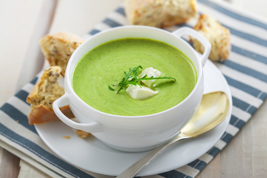 Traditional cream soup made of spinach on a table. Classic European food.