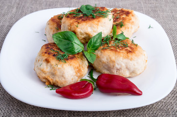 Rissole minced meat on a white plate with red pepper