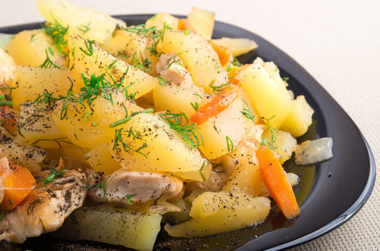 Slices of stewed potatoes, chicken, carrot and onion