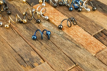 Jewelry for piercing on wooden background. Stock Image macro.