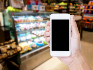 Hand holding blank screen mobile phone with blur coffee shop bac