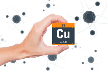 Copper element symbol handheld and atoms floating in background