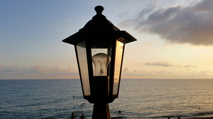 Evening seascape with a large street lamp