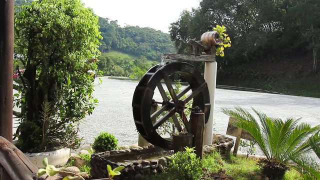 Roda d'&aacute;gua e motocicleta na estrada.