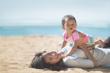 mother and baby girl playing at seaside