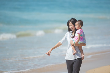 mother and baby girl playing at seaside