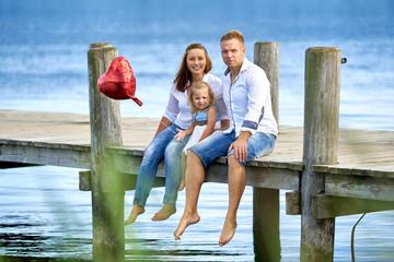 Eltern mit ihrer Tochter am See - Spaß im Sommer