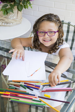 Portrait of smiling girl painting with colored pencils