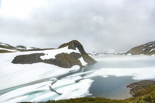 Norway, Hedmark, Tufsindalen valley, Gomma river, ice and clouds in spring