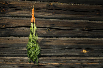 Two carrots entwined together on a wooden background