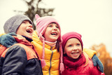 group of happy children hugging in autumn park