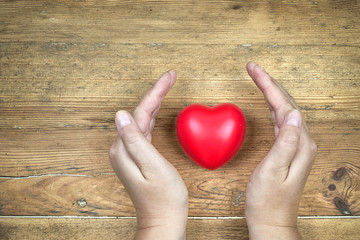 Gesundheitsschutz, rotes Herz mit schützenden Händen