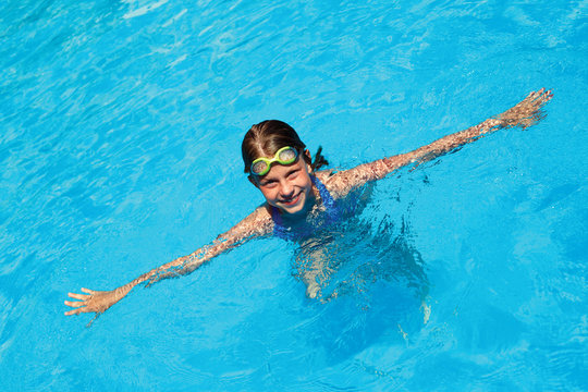 little girl swims in swimming pool