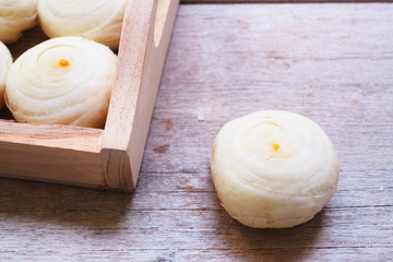 Close up of Traditional Chinese swirl moon cakes in a wooden tray.