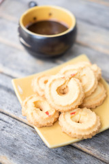 stack of fresh butter cookies in plate and hot coffee