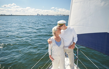 Fototapeta premium senior couple kissing on sail boat or yacht in sea