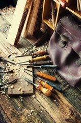 Chisels and carved piece of wood in traditional carpenter workshop