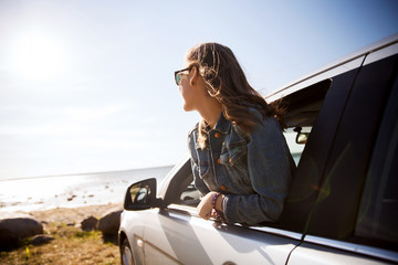 happy teenage girl or young woman in car