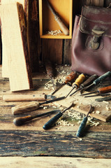 Chisels and carved piece of wood in traditional carpenter workshop
