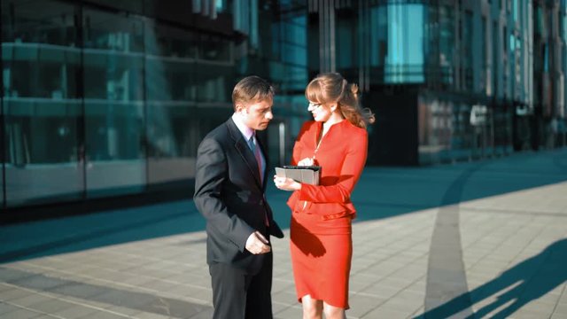 Brownhair sexy attractive Businesswoman in red dress make an offer to businessman in suit and tie. Businessman agree, smile and handshake. 4k three-fourth shot UltraHD. Glossy modern architect
