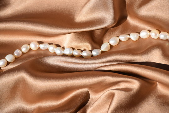 Braun- goldene Seide mit weißen Perlen 