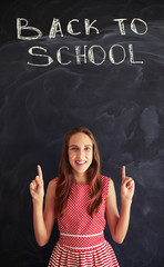 Teenage girl against chalk inscription on blackboard showing for