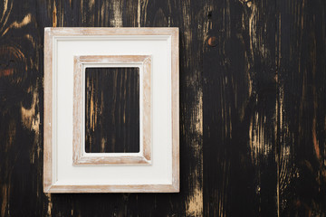 Vintage white empty frame on wooden wall