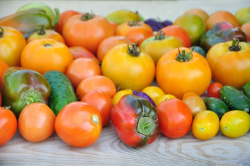 Crop of yellow and red tomatoes, cucumbers, sweet peppers. Food background.