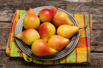 Pears on the dish and cloth on the old wood backing

