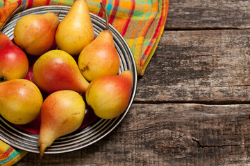 Pears on the dish and cloth on the old wood backing
