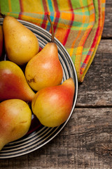 Pears on the dish and cloth on the old wood backing
