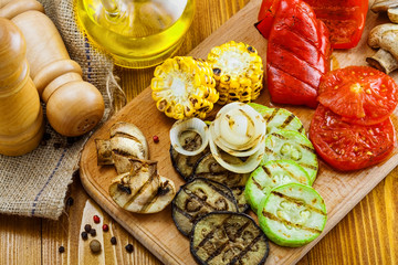Vegetables roasted on a grill: tomato, corn, eggplant, mushroom, bell pepper, marrow and onion. Delicious healthy food for lunch. Close-up shot.