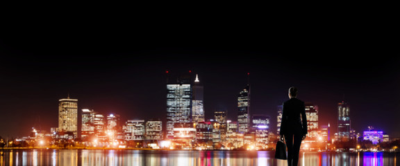 Naklejka premium Businesswoman viewing night glowing city