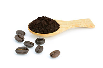 Roasted coffee powder in wooden spoon and coffee beans on white