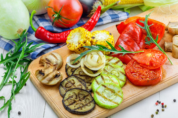 Grilled vegetables: tomato, corn, eggplant, mushroom, bell pepper, marrow and onion. Delicious healthy food and ingredients on a table.