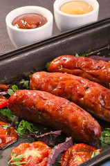 Sausage. Delicious sausages in a pan with tomato. Salad.