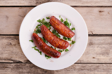 Sausage. Delicious sausages in a plate with ingredients. Salad.