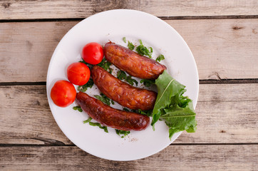 Sausage. Delicious sausages in a plate with ingredients. Salad.