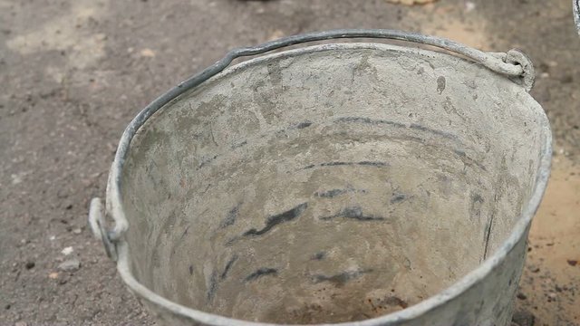 Construction pours shovel yellow sand in a bucket