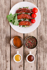 Sausage. Delicious sausages in a plate with ingredients. Salad.