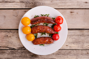 Sausage. Delicious sausages in a plate with ingredients. Salad.