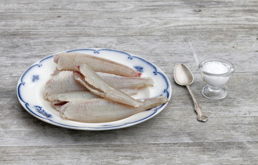 Gutted european bass fish laying on a blue and white plate