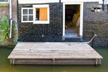 Old house with floating wooden platform on Kooltuin canal in Alkmaar, Netherlands