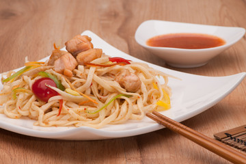 dish of noodles with meat on a plate with chopsticks